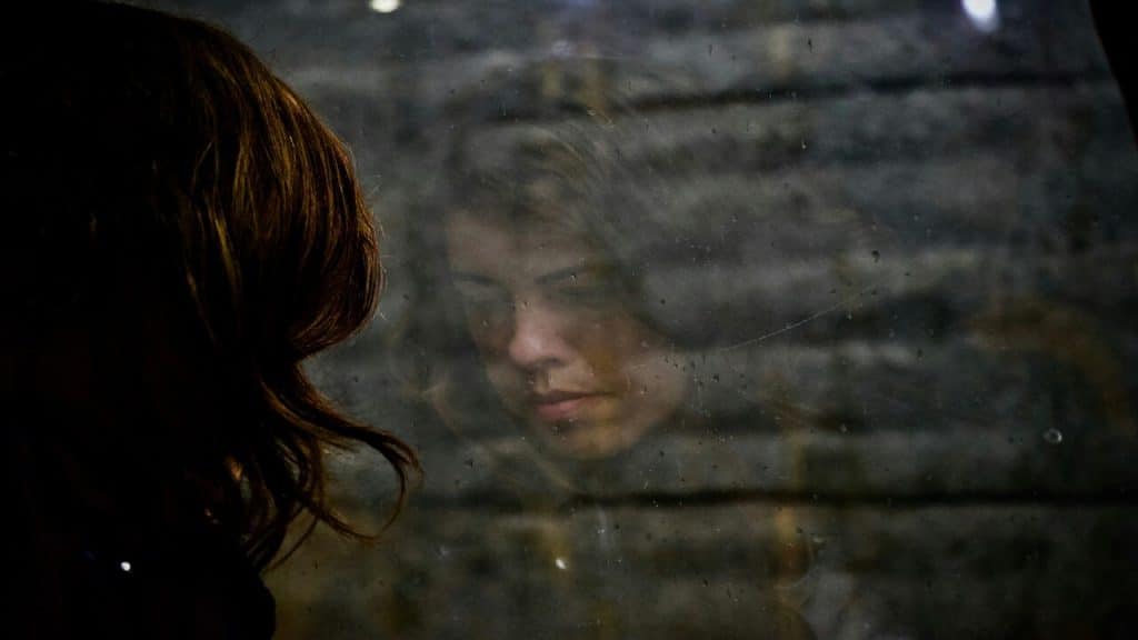 A woman looking sadly out the window