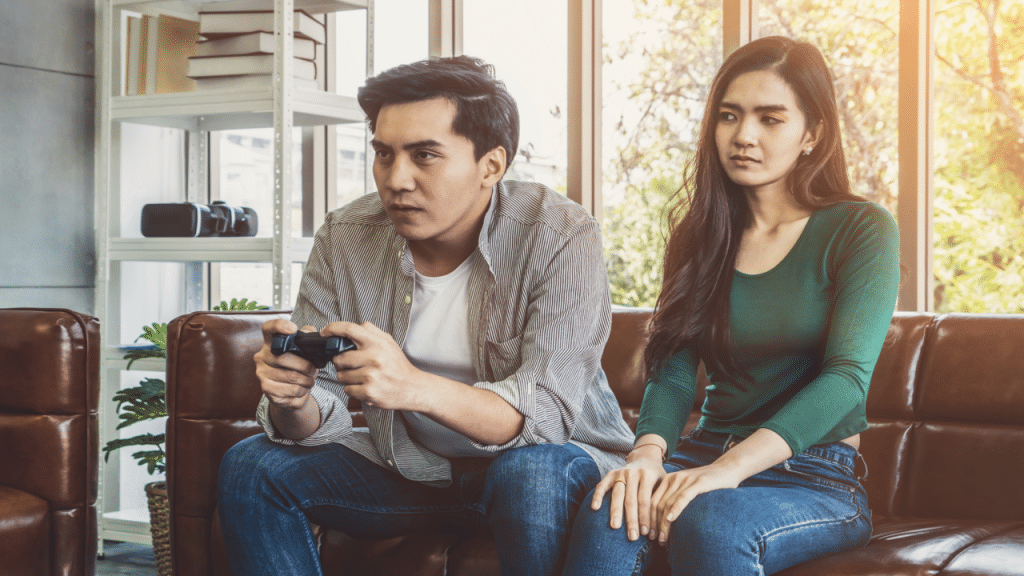 A man ignoring his wife while playing video games