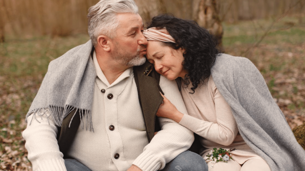 A man kissing his wife on the forehead