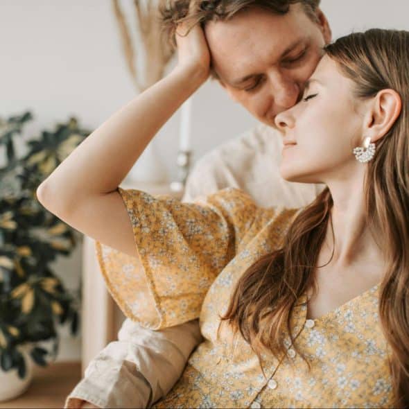 A man kissing a woman’s forehead