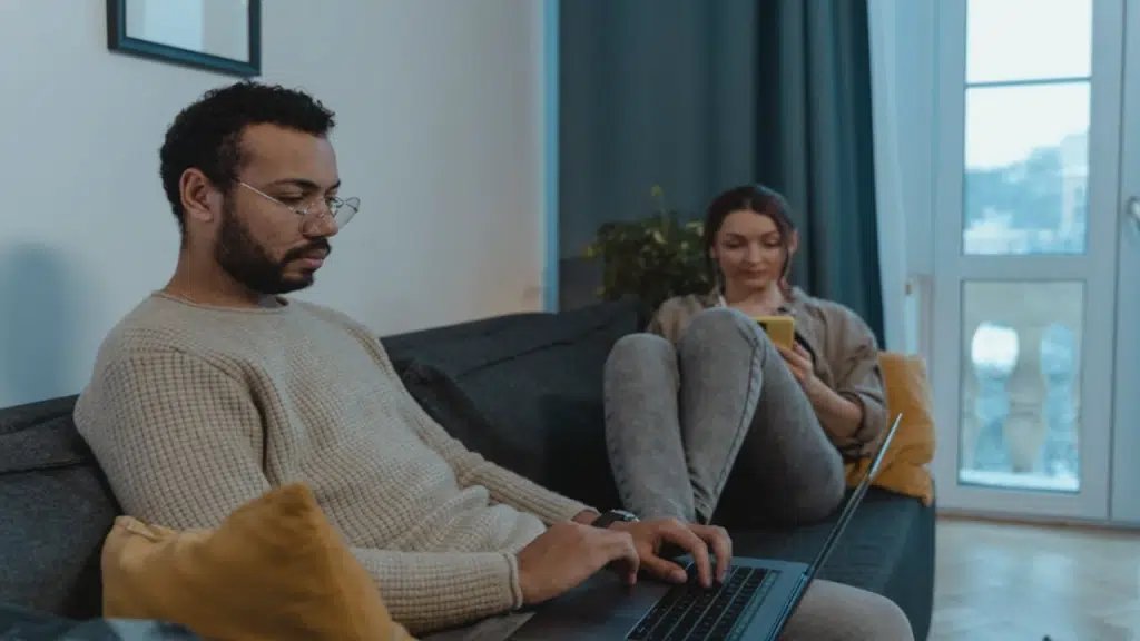 A couple ignoring each other while using their devices