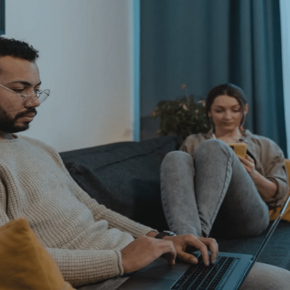 A couple ignoring each other while using their devices