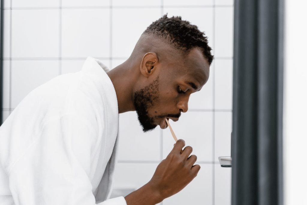 A Man in Bath Robe Brushing His Teeth