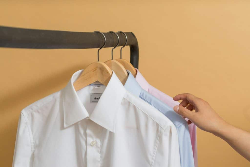 The person is choosing a button up shirt.