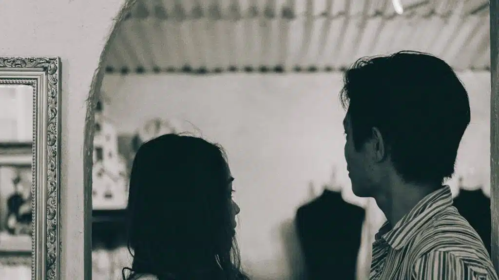 A man and a woman standing in grayscale photography.