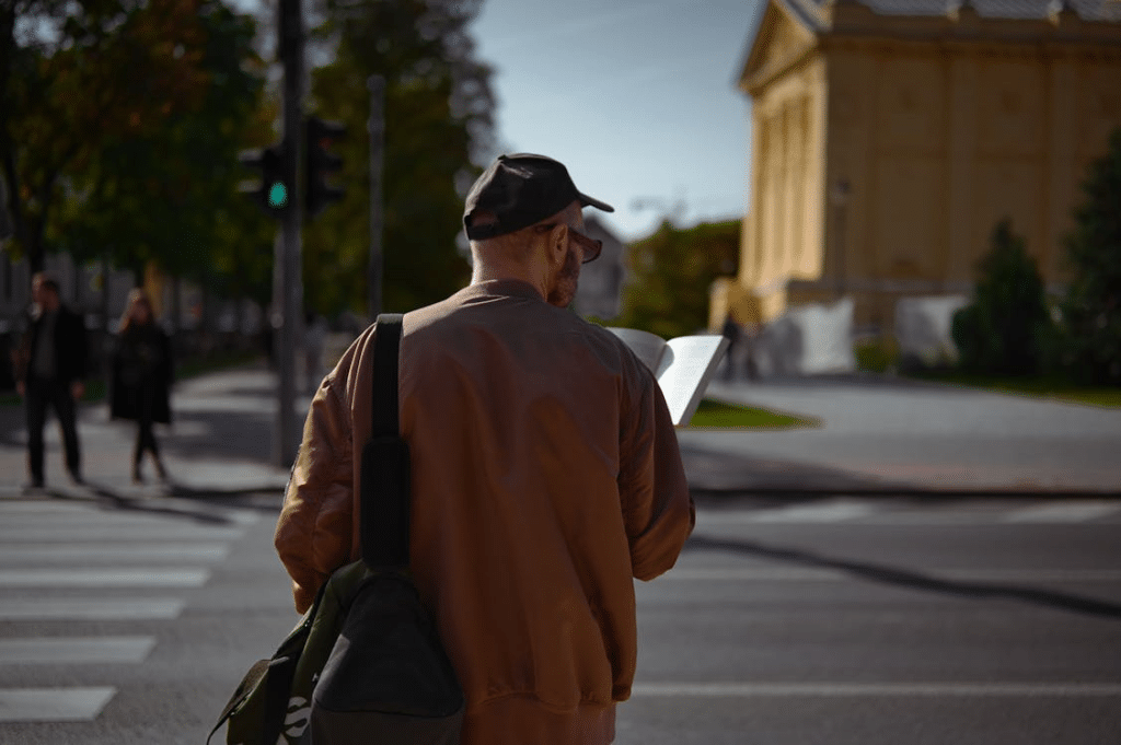 Man Reading Map at Crosswalk in Urban Setting
