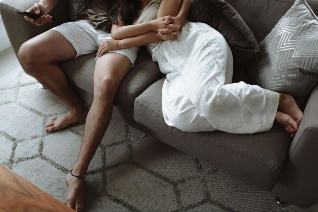 A man and woman at the sofa and embracing each other