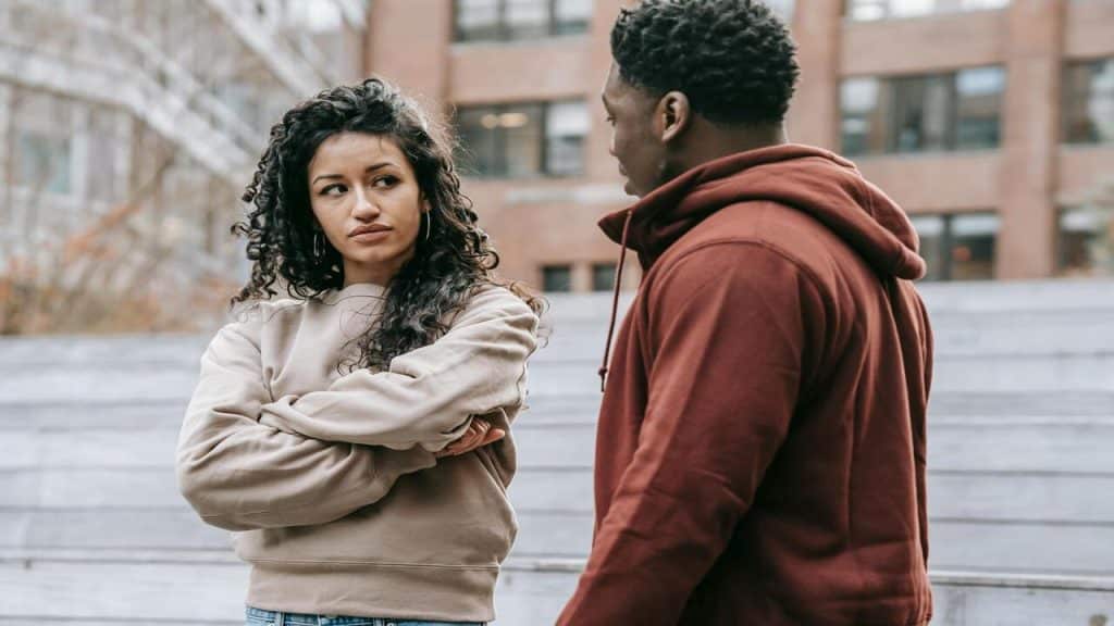 A couple arguing in front of a building