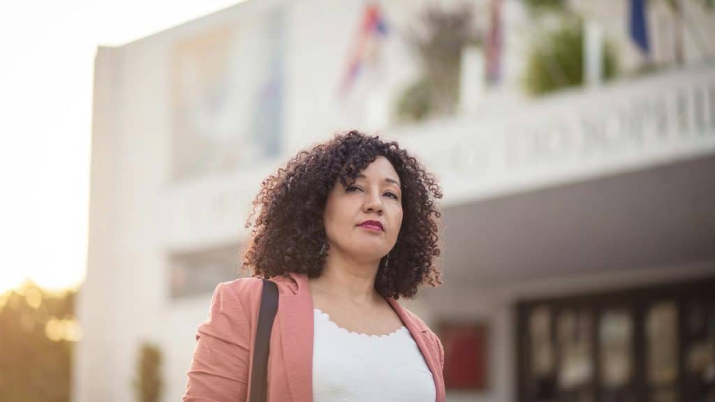 A woman standing outside with a confident expression.