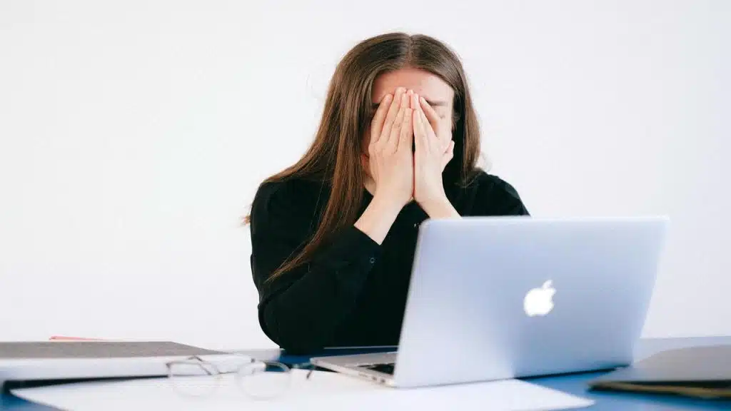 A woman looking stressed in front of her laptop
