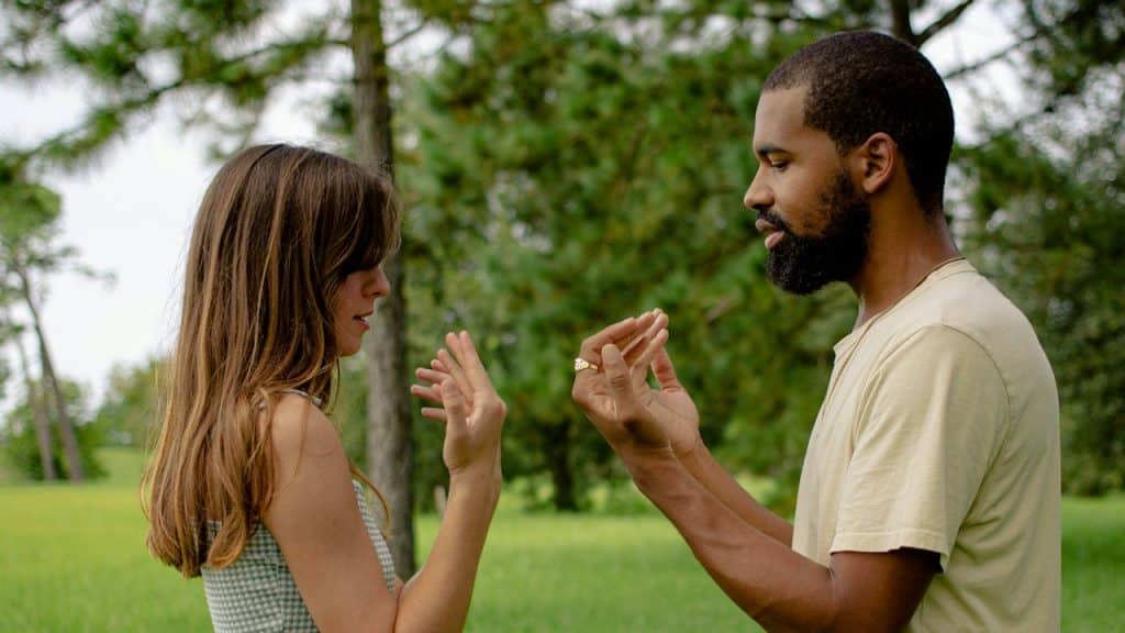 A man standing next to a woman in a field.