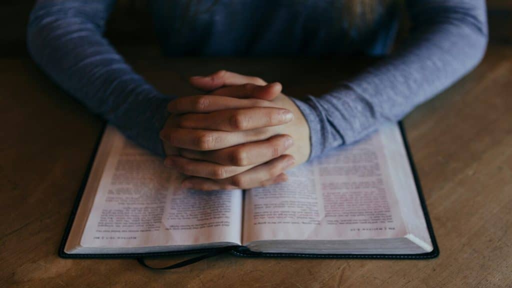 A man praying with an open bible