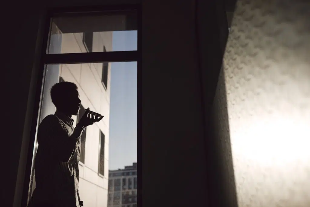 A Man Having a Phone Call near the Window