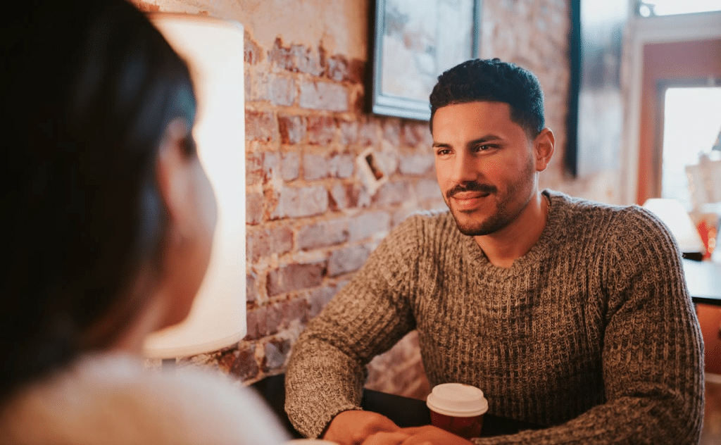 Couple sitting at cafe together with coffee cup