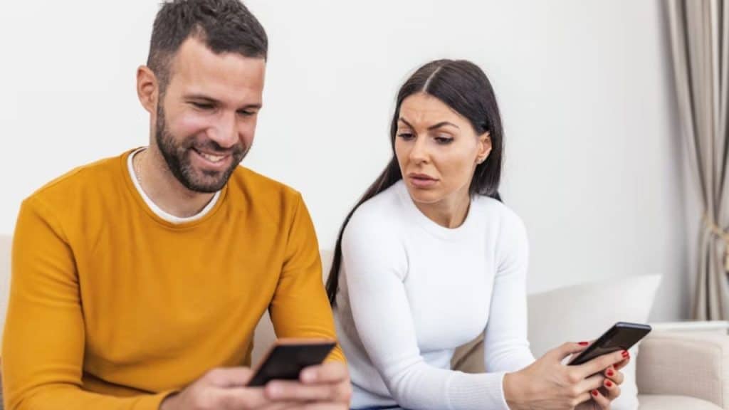 Man looking at his phone as his partner questions his plans