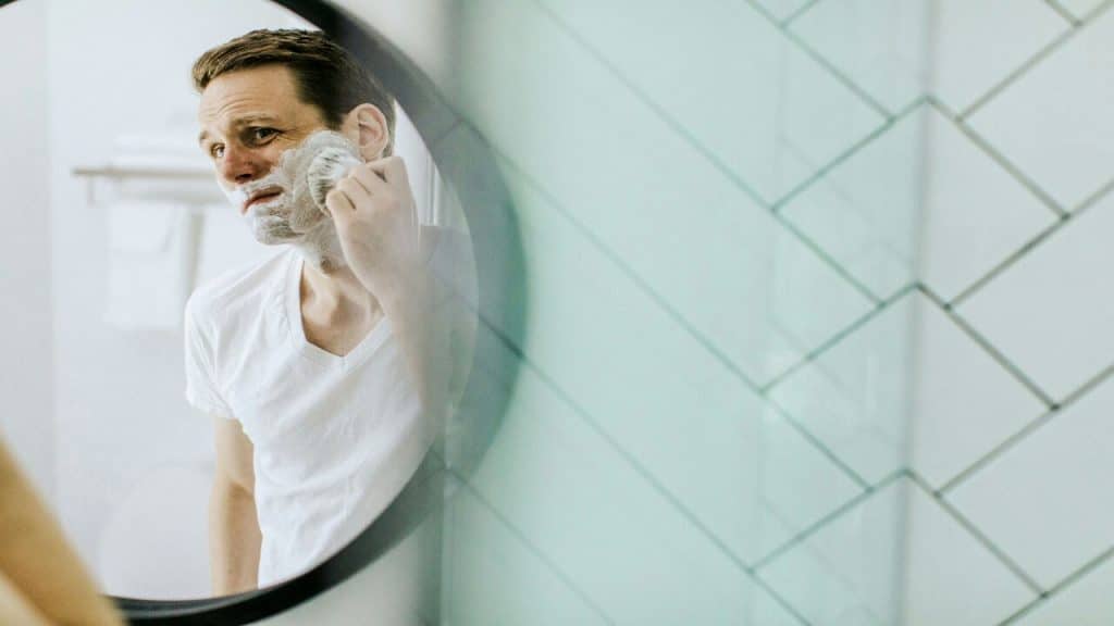 A man shaving in front of a mirror 
