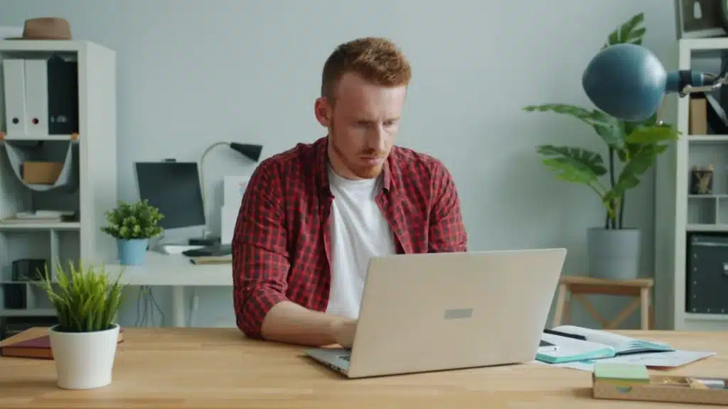 Man reviewing finances on a laptop in a minimalist workspace