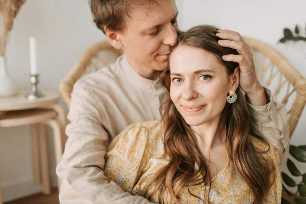 A man kissing and caressing woman’s head