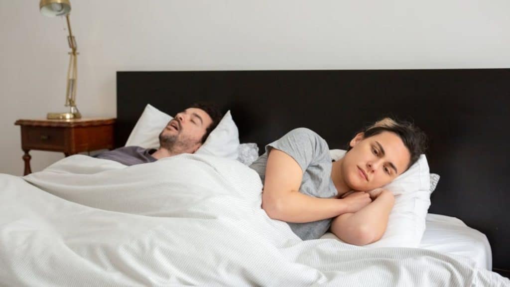 Couple showing emotional and physical distance in bed