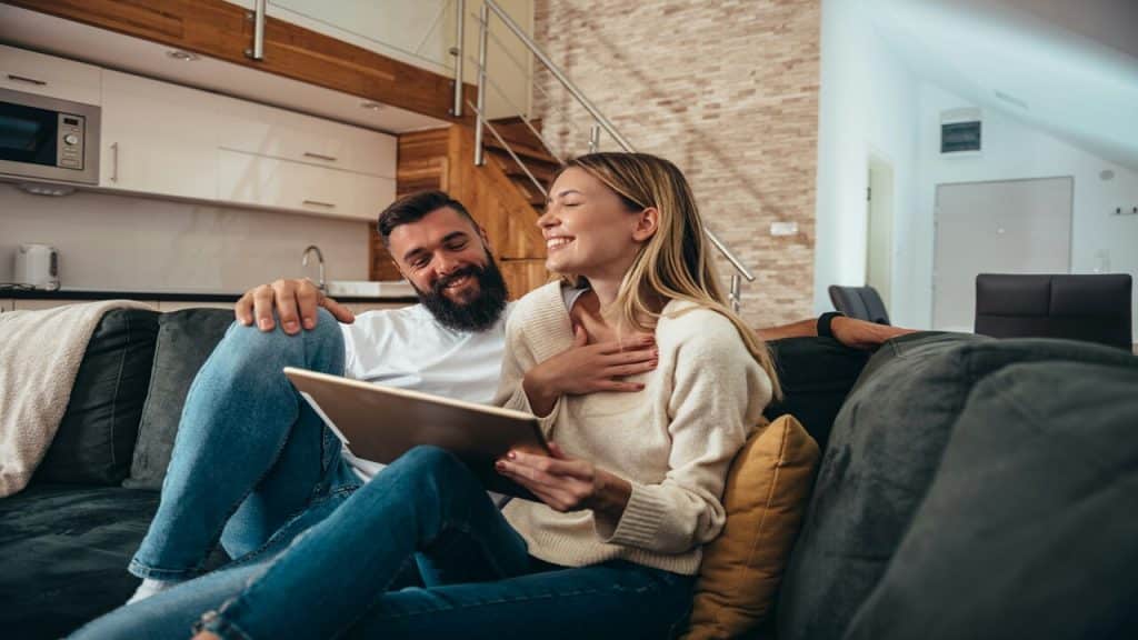 A couple laughing together in the living room