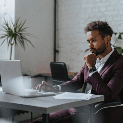 A Man in Maroon Suit Sitting at the Table