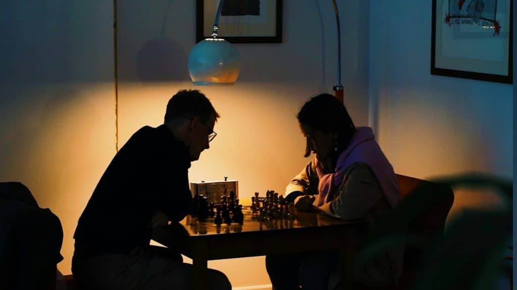 A couple playing a chess game at a cafe.
