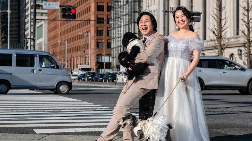 A man and a woman posing for a picture with two dogs.