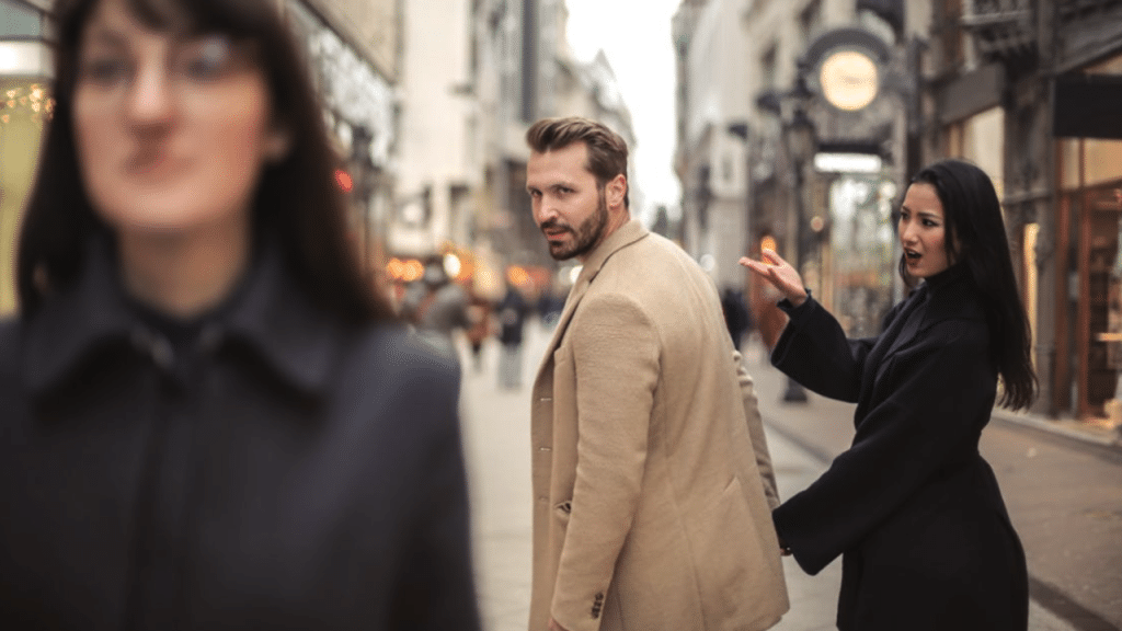 A man looking at another woman while with his wife
