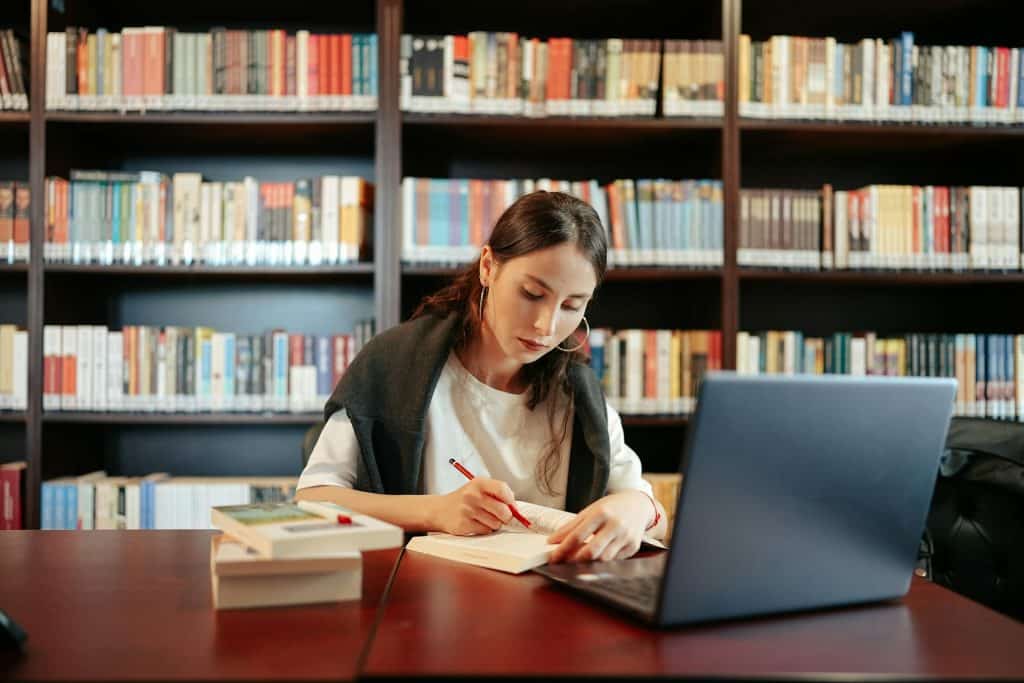 The woman is studying in the library.