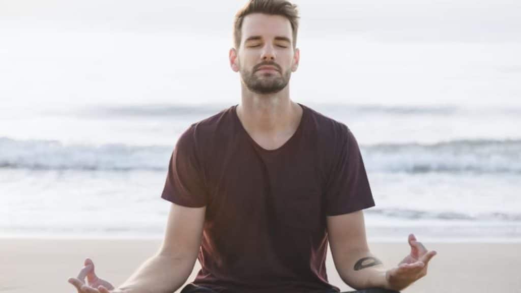 Man practicing mindfulness outdoors, calm expression, soft sunset light.