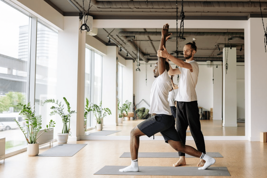 A Yoga Instructor Teaching a Student in a Yoga Class