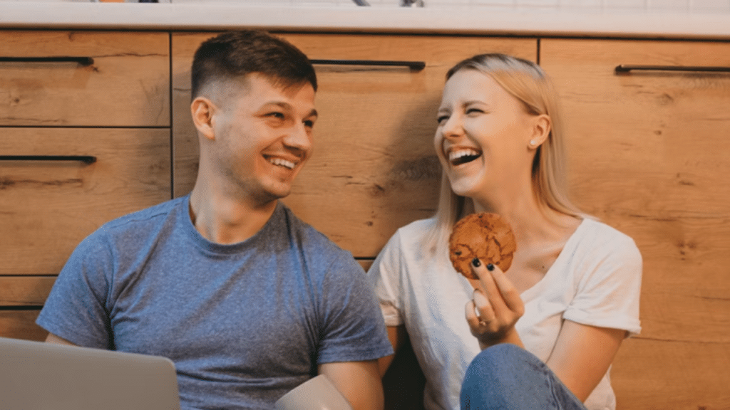 A couple laughing together in the kitchen 