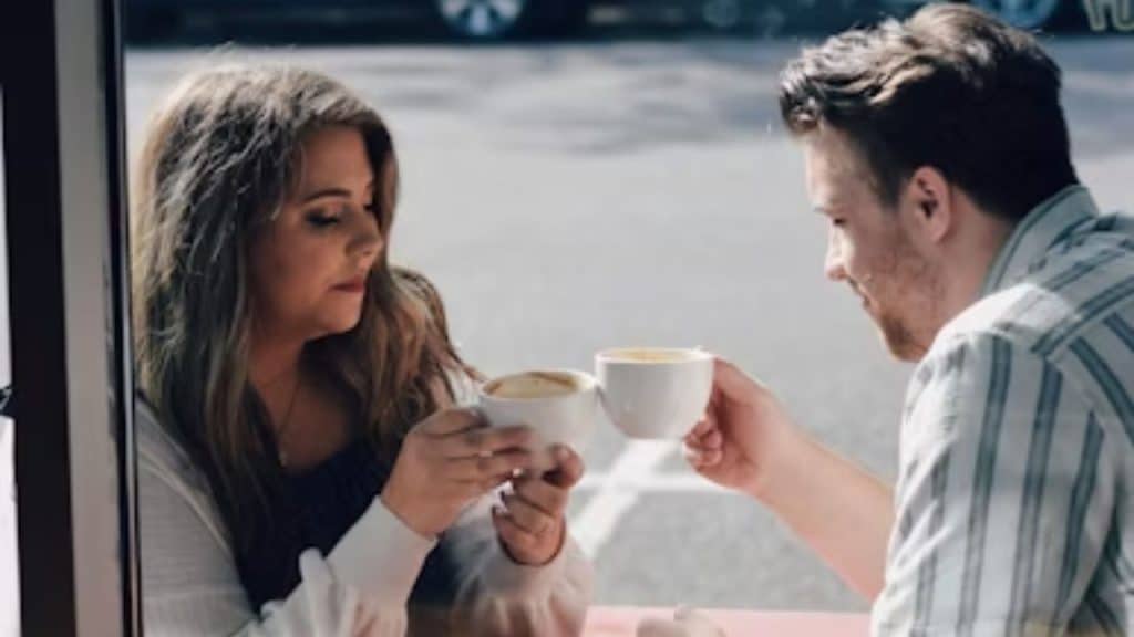 Couple sitting at a café, woman hesitating before speaking