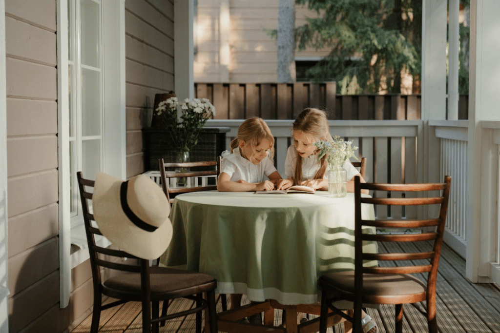 Young Girls Reading a Book at a Veranda