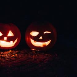 Two Pumpkin jack-o-lanterns glowing in the dark.