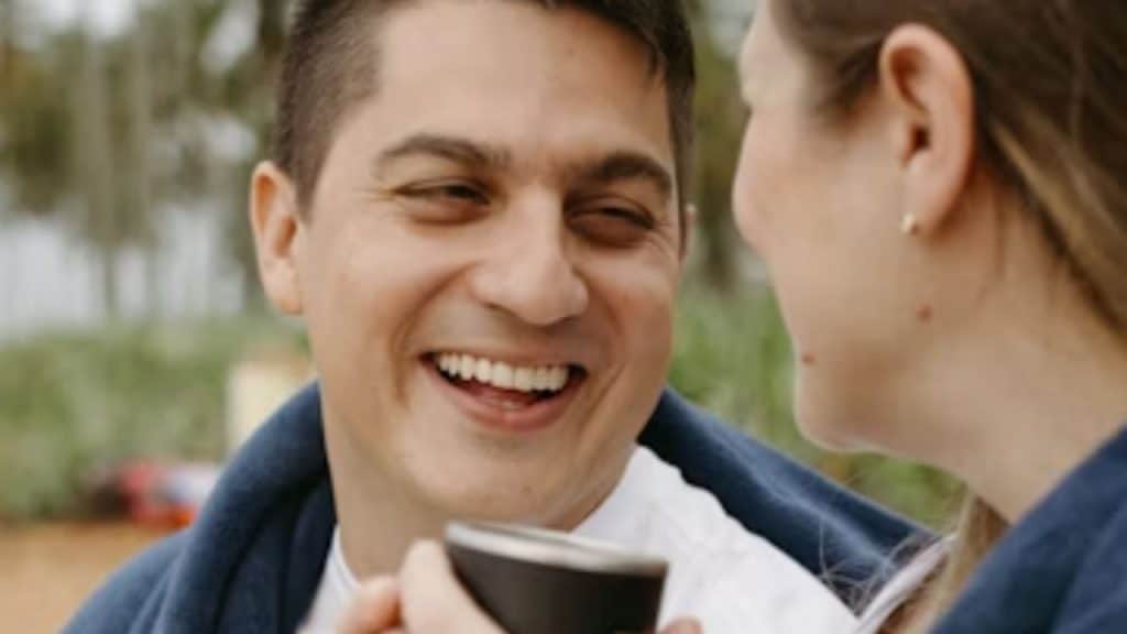 Man surprising his partner with coffee and a smile