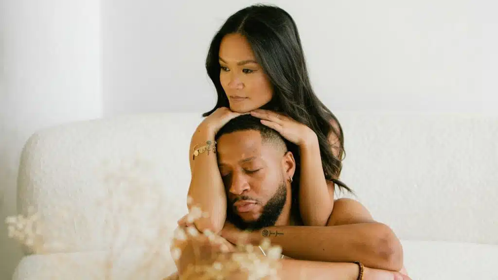 A woman resting her face atop her partner’s who has his eyes closed. 