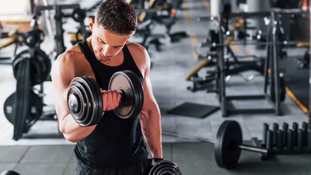 A man alone at the gym lifting weights