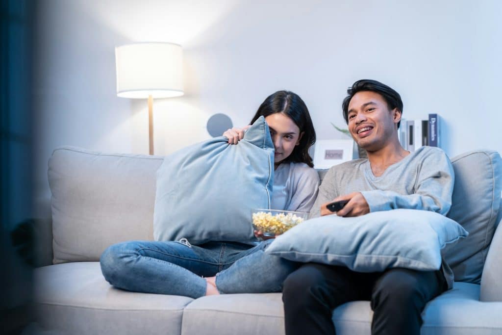 The young couple is watching a movie together.