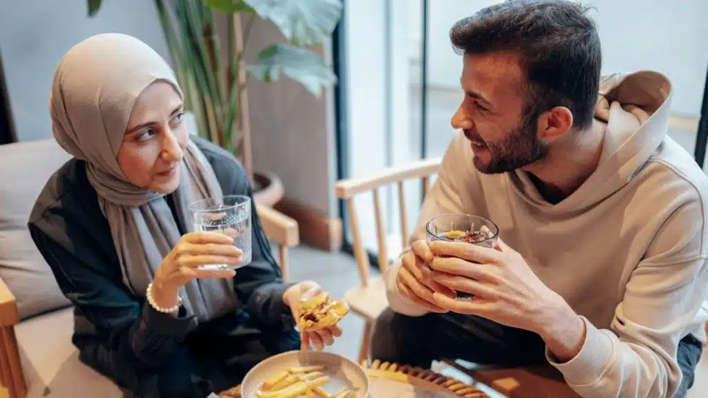 A man and a woman sitting at a table with food.