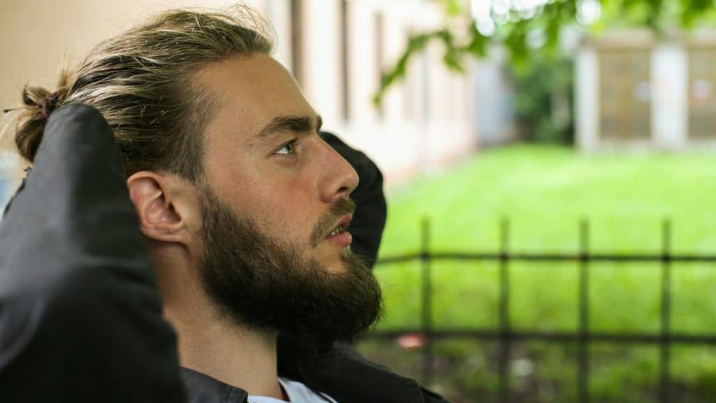 A person leaning back outdoors and looking upward.