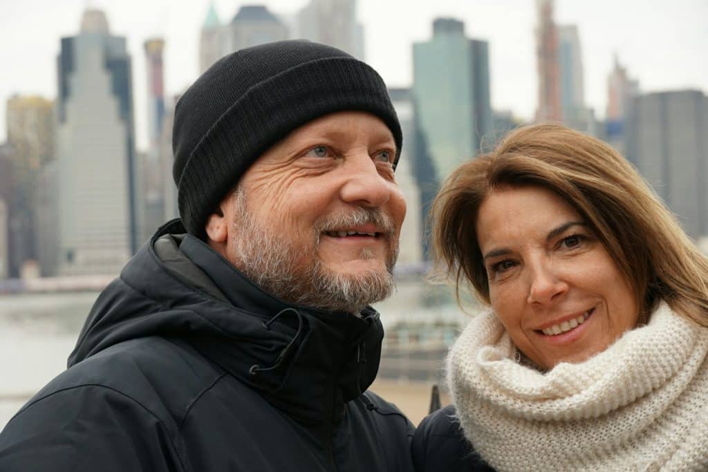 The couple is standing beside each other and spending time outdoors.