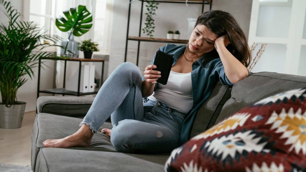 A woman crying while looking at her phone