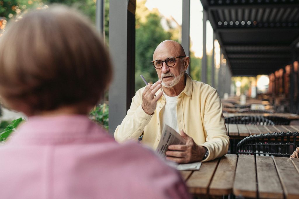 The elderly couple is talking outside.