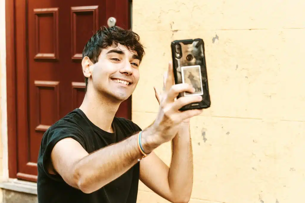 The man is taking a photo with his smartphone.