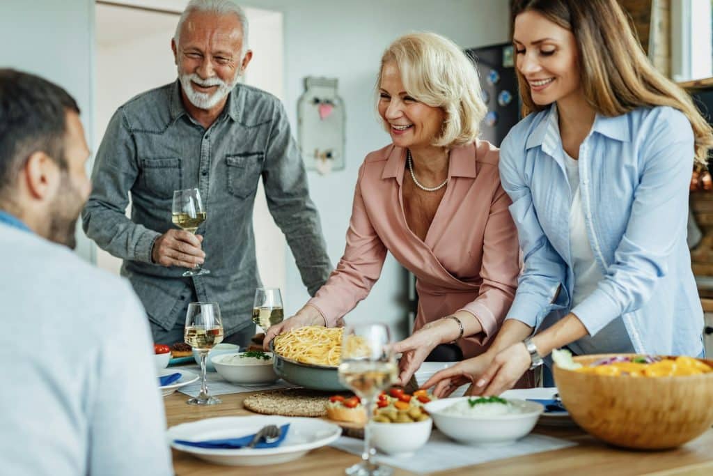 The mother and daughter are serving lunch.