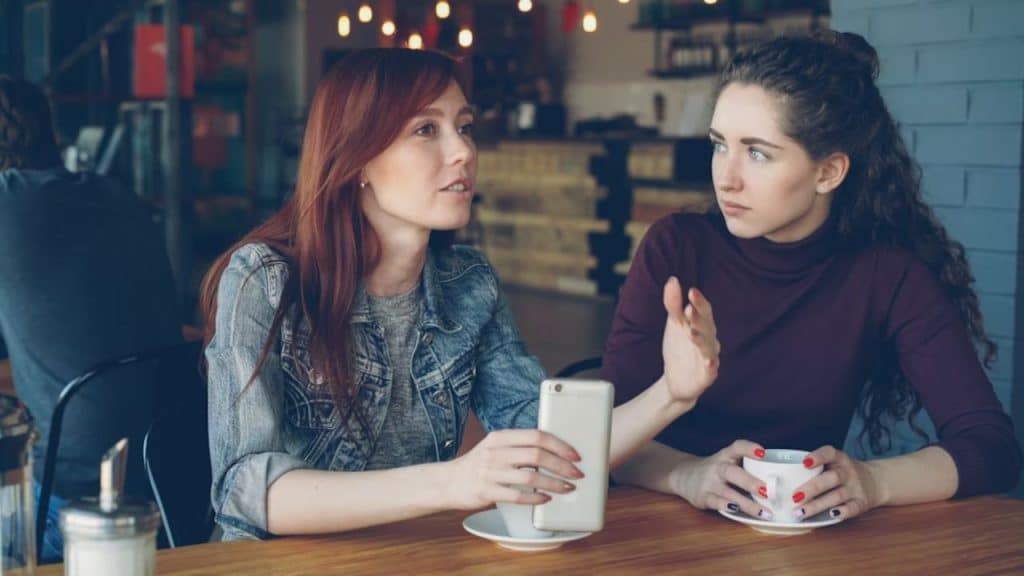 Woman talking to her friend over coffee, expressing frustration