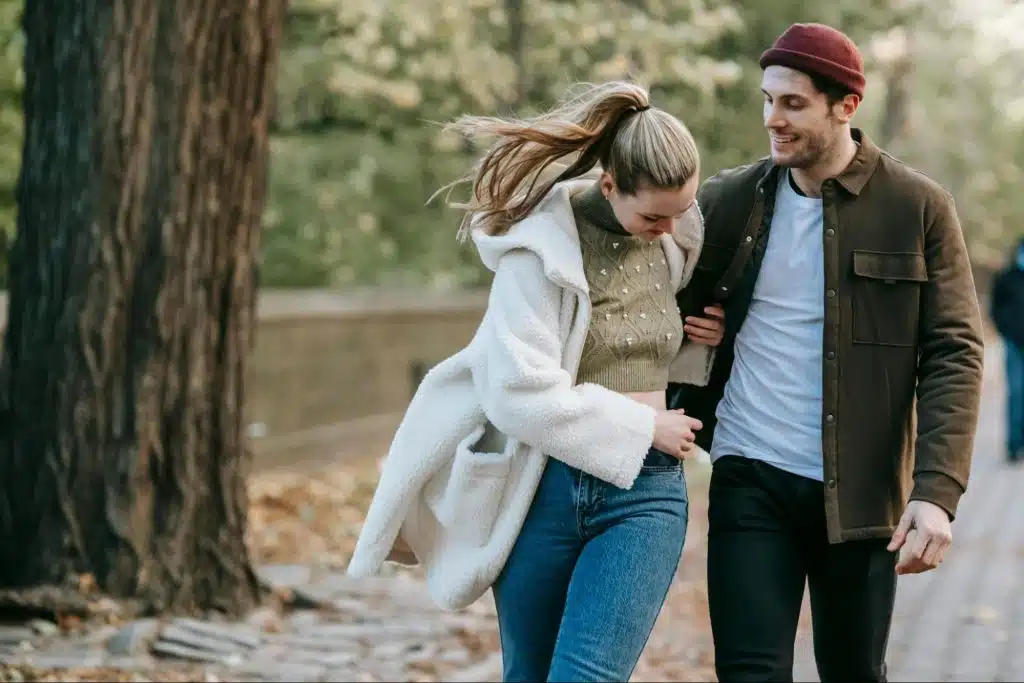 A man and woman walking outside 