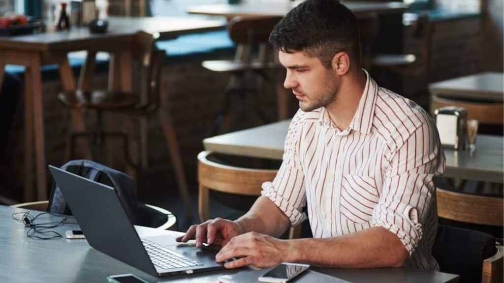 Man writing reflections oh his laptop to gain emotional self awareness