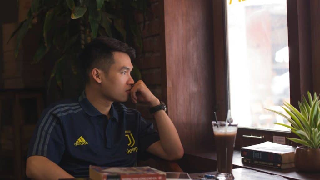 Man sitting alone at a coffee shop, thinking deeply